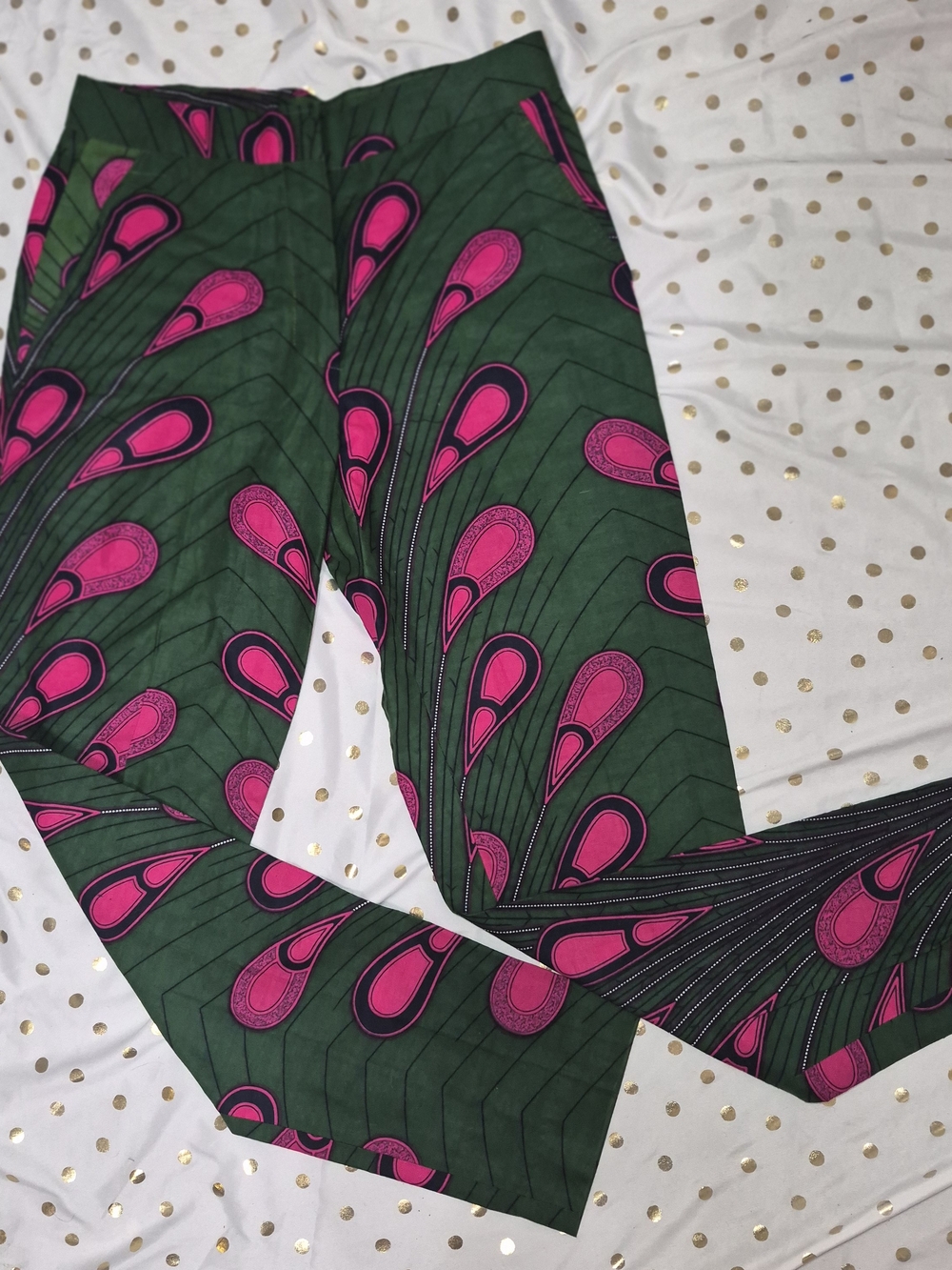 Queen E. Collection green trousers with a vibrant pink and black peacock feather